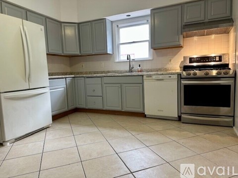 A kitchen with a white fridge, white oven, and a window.