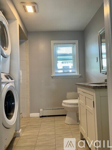 A laundry room with a washer and dryer stacked on top of each other.