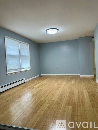A room with wooden flooring and a window.