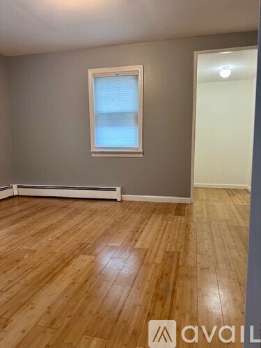 A room with wooden flooring and a window.