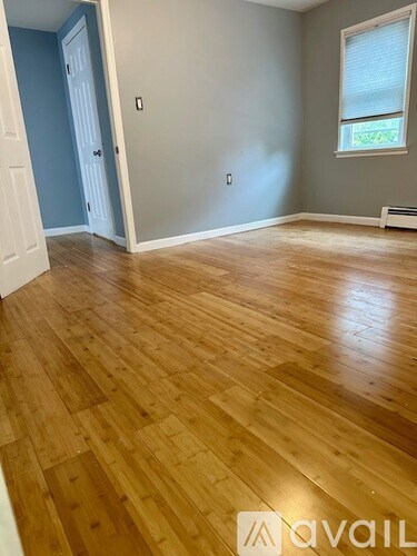 A room with wooden flooring and a window.