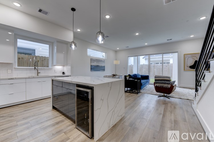 A modern kitchen with a large island and a view of the backyard.