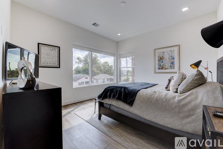 A bedroom with a bed, a chair, a dresser, and a painting on the wall.