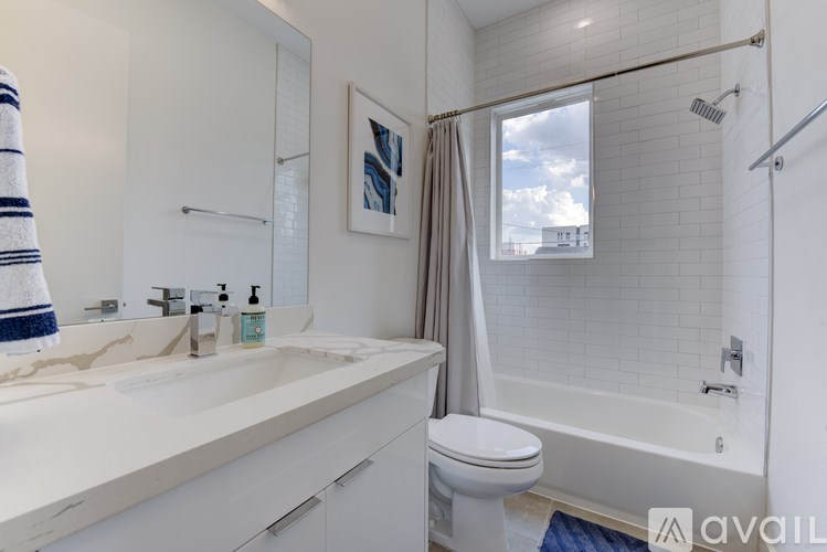 A bathroom with a white toilet, sink, and bathtub.