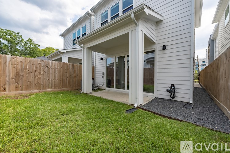 A white house with a wooden fence and a small garden.