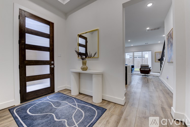 A hallway with a blue rug and a wooden door.