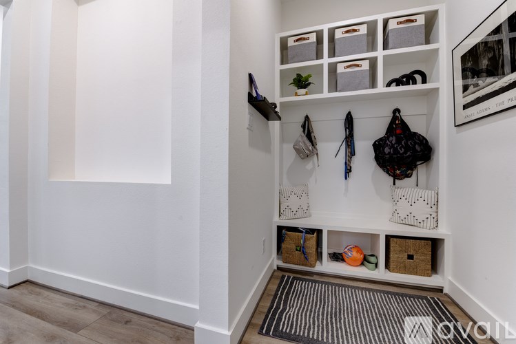 A hallway with a bench and a bag hanging on the wall.