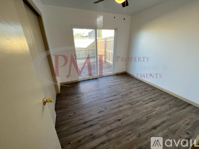 A room with wooden flooring and a door leading outside.