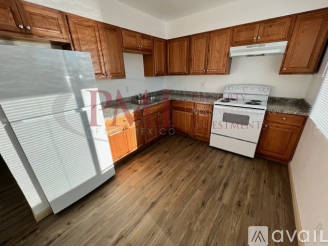 A kitchen with wooden cabinets and a white stove top oven.