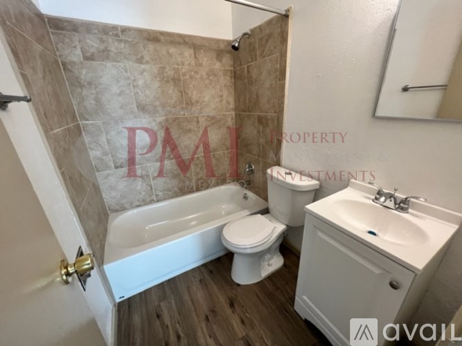 A bathroom with a tub, toilet, and sink.