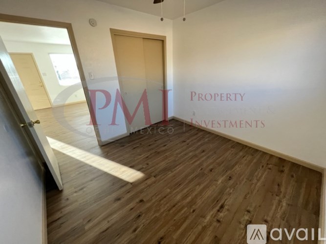 A room with wooden flooring and a wall with the letters "PMT" written on it.