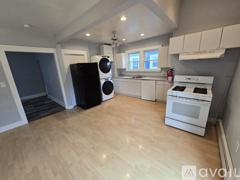 A kitchen with white cabinets and a white stove top oven.