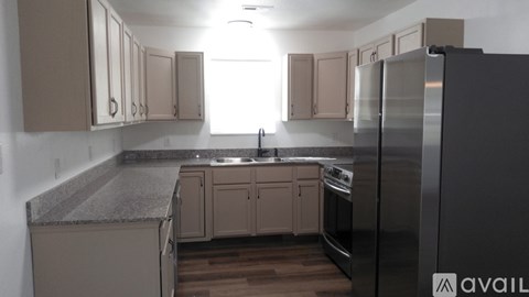 A kitchen with a refrigerator on the right side.