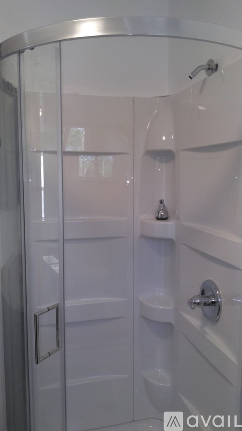 A white bathroom with a glass shower door.