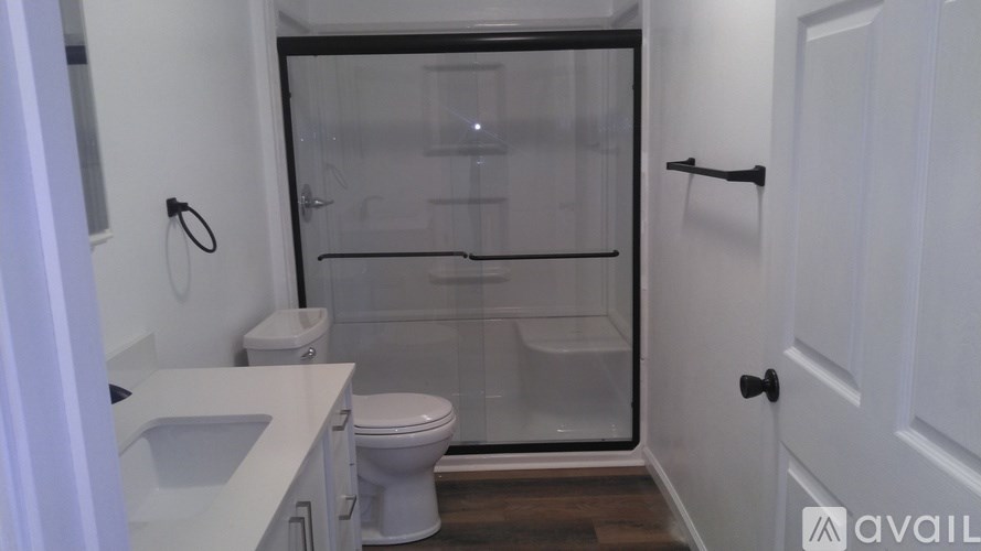 A bathroom with a toilet, sink, and shower.