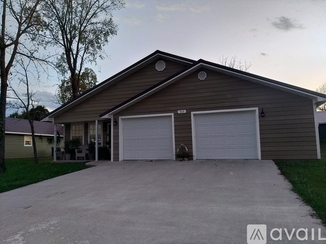 A two-car garage with a house in the background.