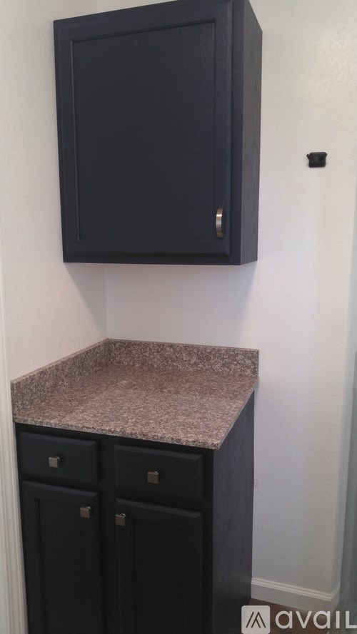A black cabinet with a granite countertop.