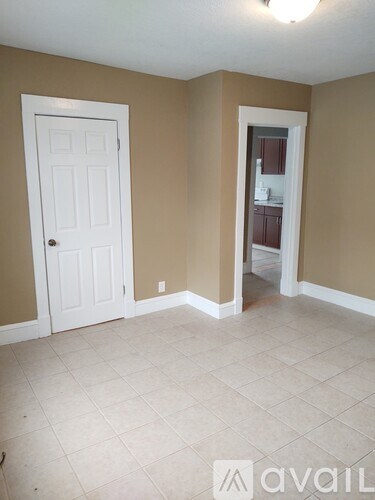 A room with a white door and a white cabinet in the other room.