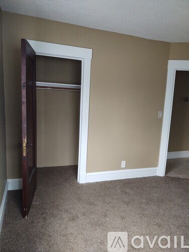 A room with a carpeted floor and a white door frame.