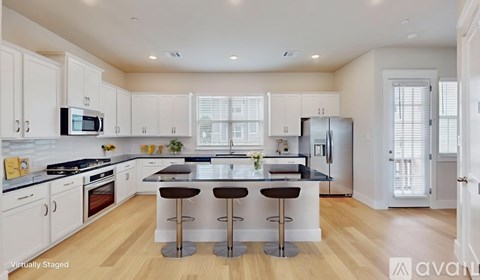 A kitchen with white cabinets and a black countertop.