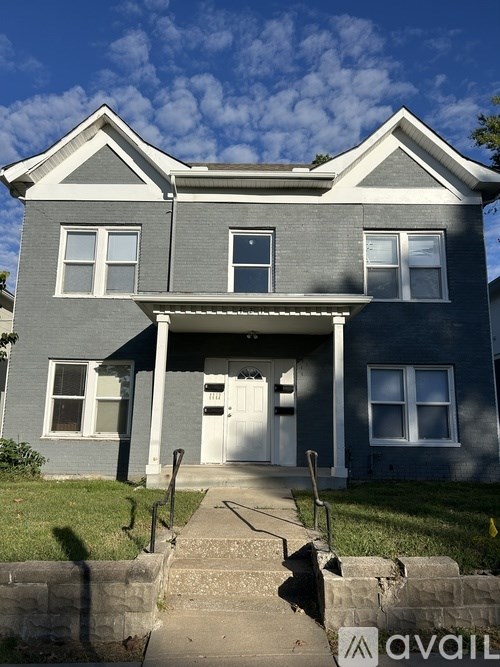 A two-story house with a front porch and a white door.