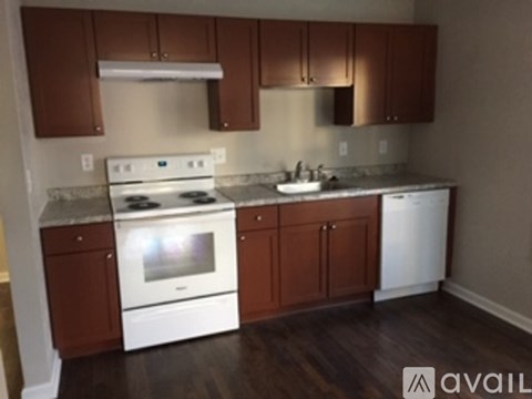 A kitchen with white appliances and brown cabinets.