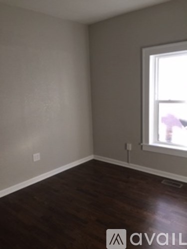 A room with a window and wooden floors.