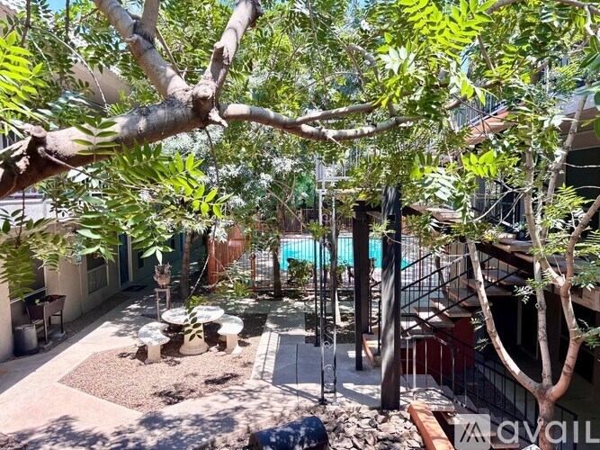 A patio with a table and chairs is surrounded by trees.