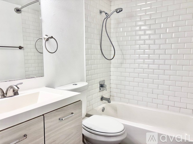 A white bathroom with a toilet, sink, and bathtub.