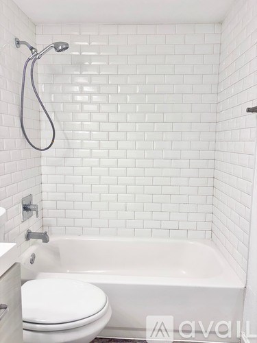 A white toilet in a white tiled bathroom.
