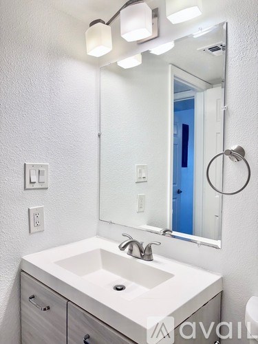 A bathroom with a white sink and a mirror above it.