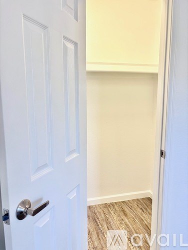 A white door with a silver handle is open.