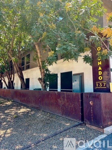 A building with a sign that reads "ONDAR 137" is surrounded by trees.