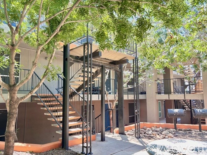 A tree is in front of a building with a staircase.
