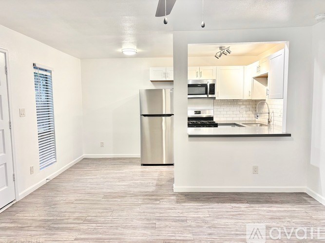 A kitchen with a refrigerator, microwave, and oven.