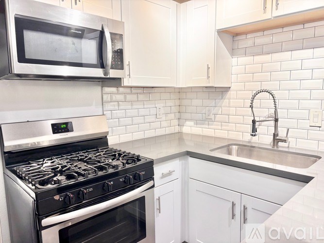 A kitchen with a stove, microwave, and cabinets.