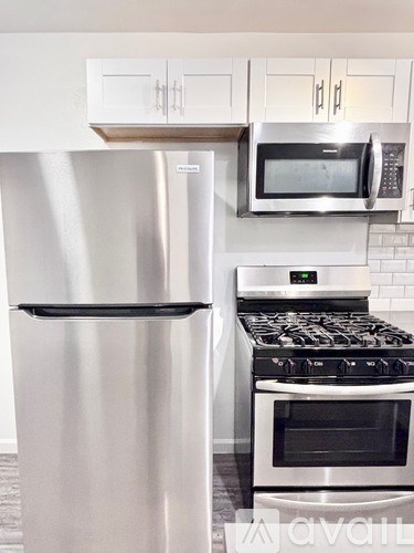 A stainless steel refrigerator and microwave in a kitchen.