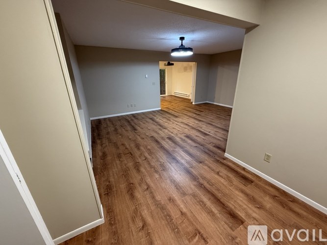 A room with wooden flooring and a light fixture hanging from the ceiling.