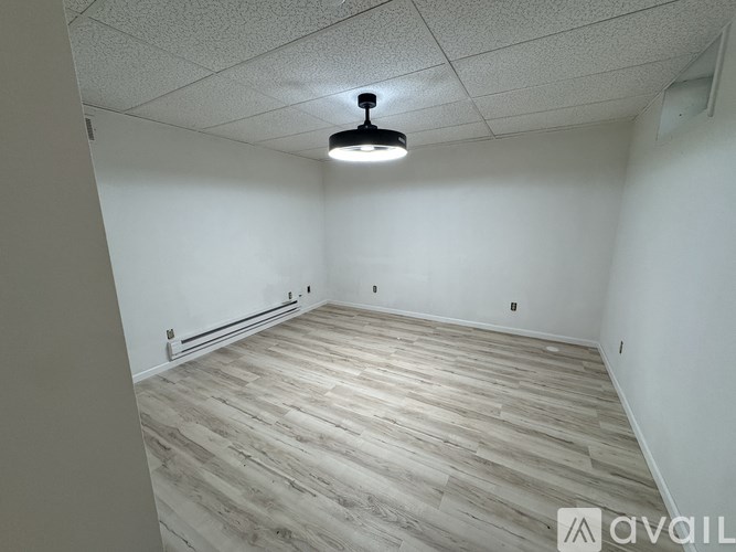 A room with wooden flooring and a ceiling light.