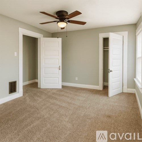 A room with a ceiling fan and carpeted floor.