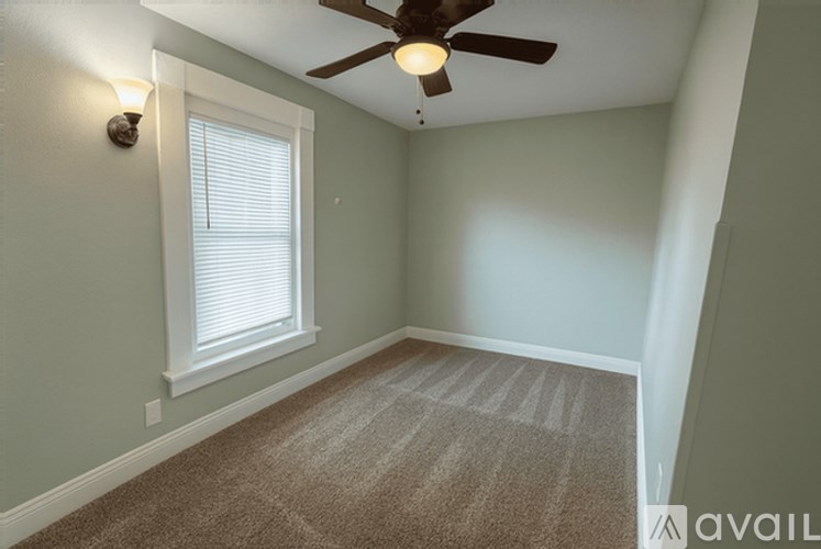 A room with a ceiling fan and a window with blinds.