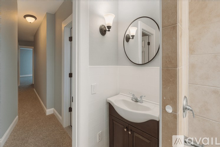 A bathroom with a sink, mirror, and towel rack.