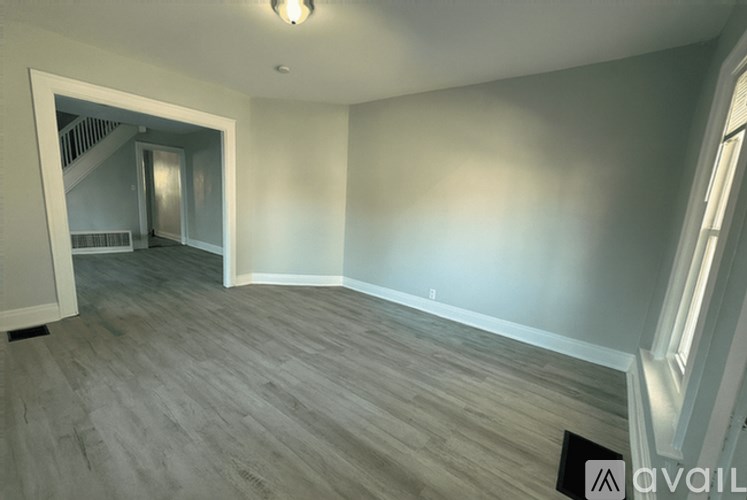 A spacious room with a staircase leading to another room.