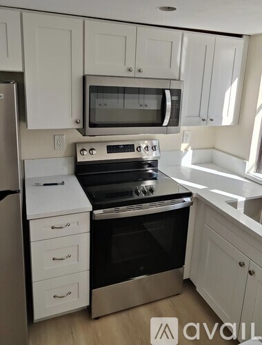 A kitchen with white cabinets and a stainless steel oven.