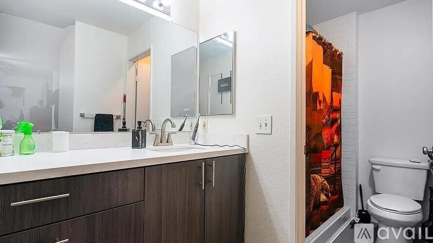 A bathroom with a toilet, sink, and mirror.