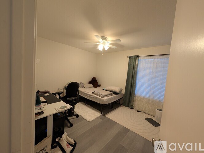 A pool surrounded by chairs and trees with a house in the background.