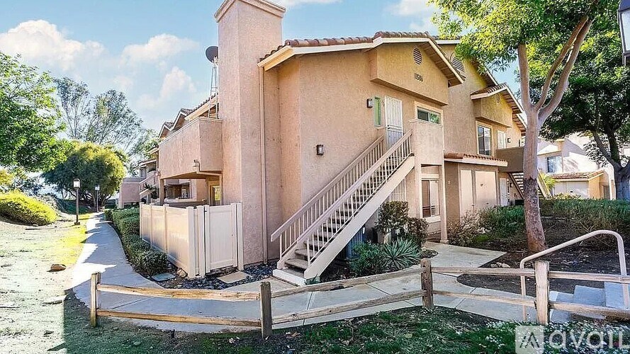 A beige house with a staircase leading to the front door.