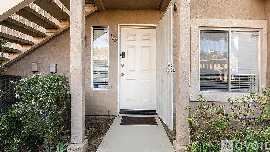 A beige house with a white door and a small porch.
