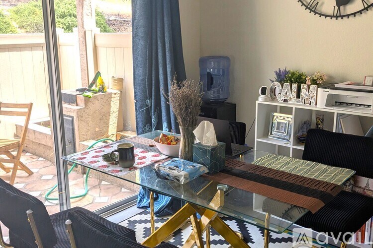 A glass table with a blue cloth and a vase with dried flowers on it.