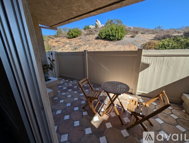 A black bag is leaning against a white wall next to a white washing machine and dryer.
